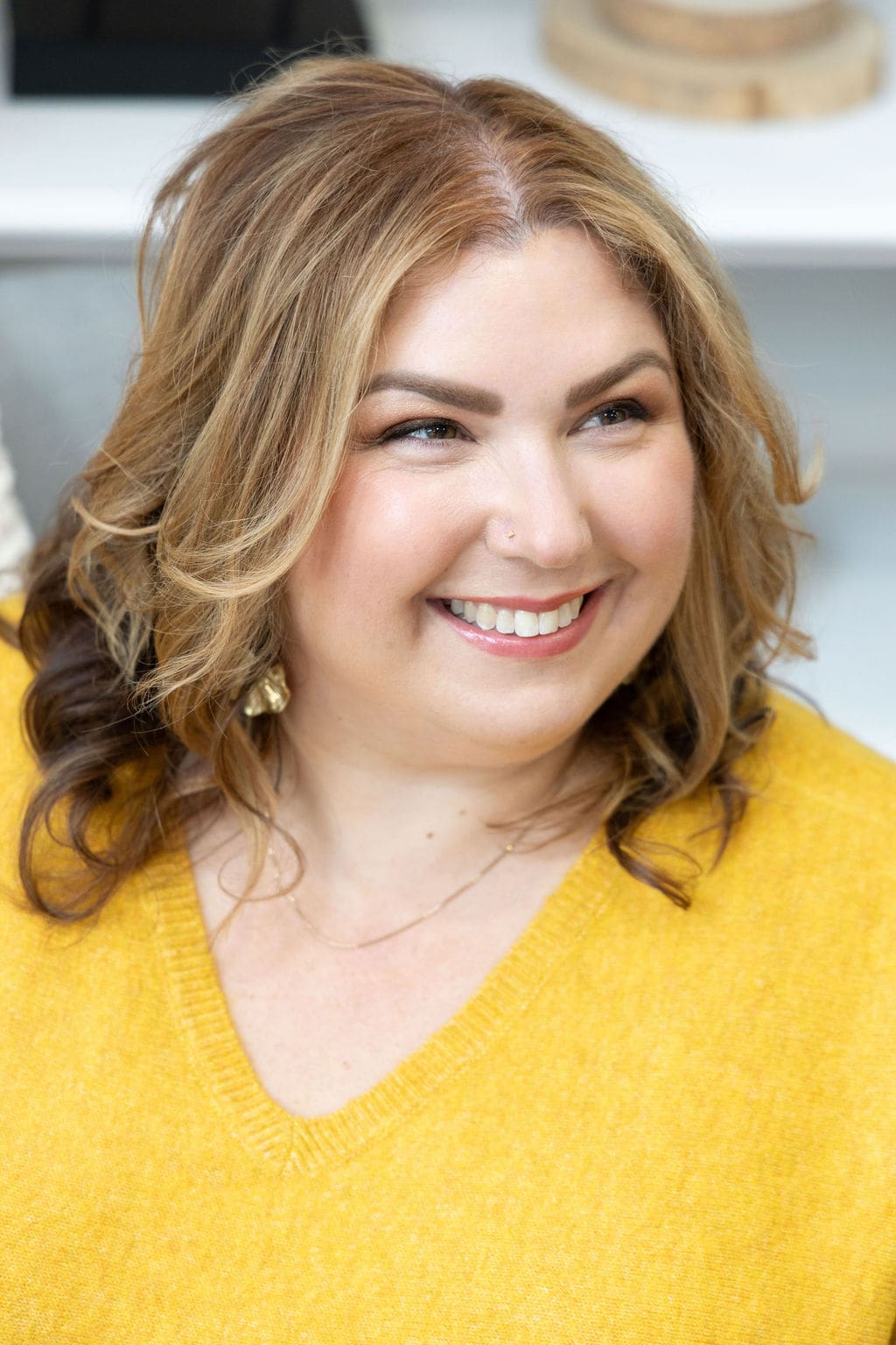 The Empowered Therapist, mentor and somatic experiencing practitioner, standing in yellow shirt and smiling off into the distance.